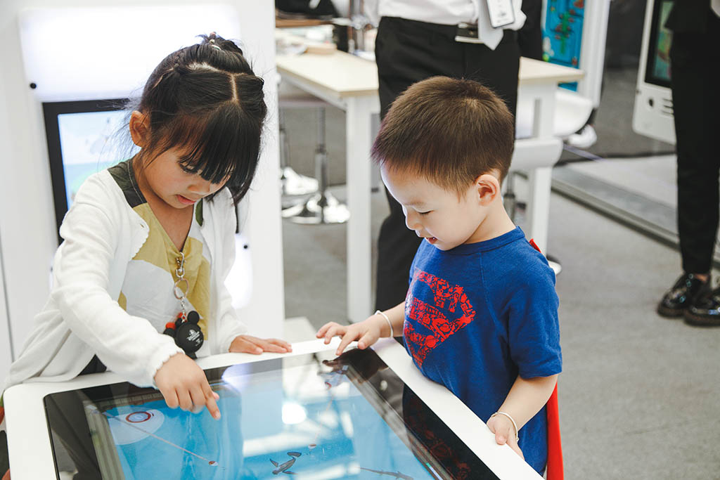 twee kinderen druk aan het spelen met de interactieve spelsystemen van IKC twee kinderen druk aan het spelen met de interactieve spelsystemen van IKC