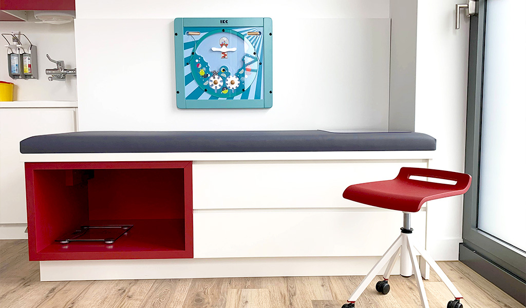 Behandelruimte met leuk wandspel voor kinderen Wandspel boven behandeltafel